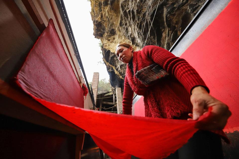 This photo taken on January 5, 2020 shows a worker making red paper used for Lunar New Year decorations, in Danzhai in China's southwestern Guizhou province.