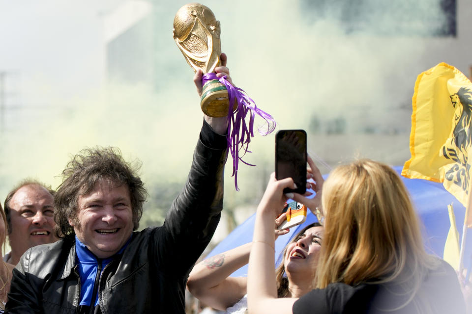 Presidential hopeful Javier Milei, of the Liberty Advances coalition, holds up a replica of the World Cup soccer trophy during a campaign rally in Lomas de Zamora, Argentina, Monday, Oct. 16, 2023. General elections are set for Oct. 22. (AP Photo/Natacha Pisarenko)