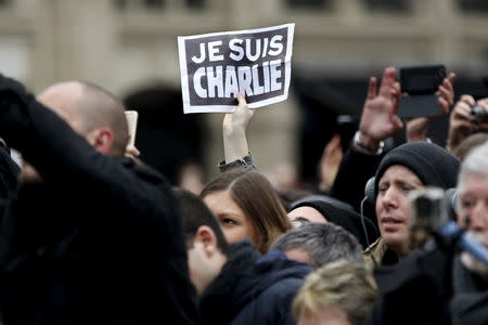 A person holds up a "Je Suis Charlie" (I am Charlie) sign during a ceremony at Place de la Republique square to pay tribute to the victims of last year's shooting at the French satirical newspaper Charlie Hebdo, in Paris, France, January 10, 2016. REUTERS/Yoan Valat/Pool/Files