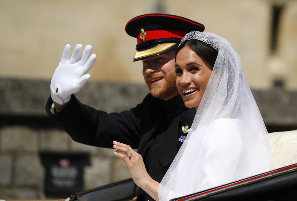 The royal couple wave to the crowds from their horse-drawn carriage (Picture: PA)