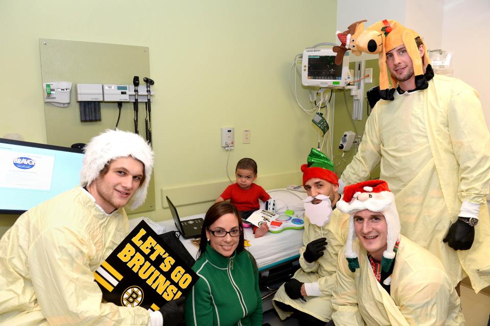 Tim Schaller, top right, and some Boston Bruins teammates visit a patient at Boston Children's Hospital in 2017.