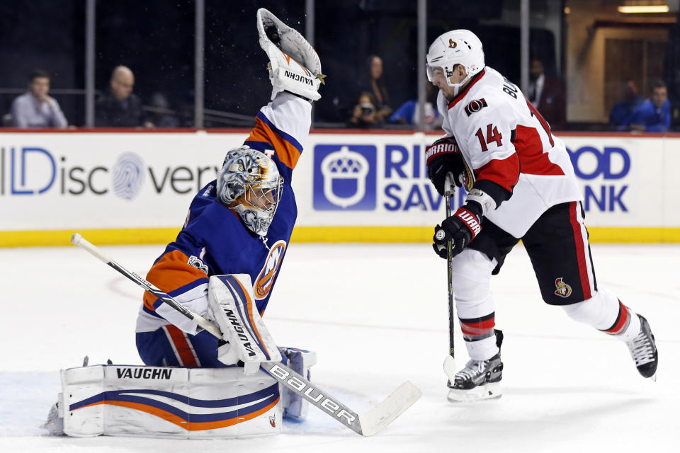 New York Islanders goalie Thomas Greiss (1) makes a glove save in front of Ottawa Senators left wing Alexandre Burrows (14) in the first period of an NHL hockey game, Sunday, April 9, 2017, in New York. (AP Photo/Adam Hunger)