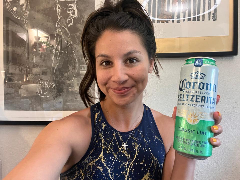 chelsea holding a can of lime corona hard seltzer