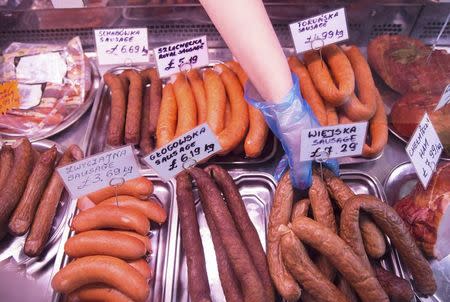 A worker reaches for sausage at a Polish delicatessen in Grays in southern Britain December 11, 2015. REUTERS/Neil Hall