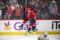 Washington Capitals center Nic Dowd (26) celebrates his goal with T.J. Oshie (77) during the third period of an NHL hockey game as Boston Bruins left wing Brad Marchand (63) skates away, Monday, April 15, 2024, in Washington. The Capitals won 2-0. (AP Photo/Nick Wass)