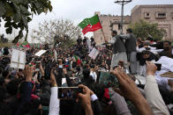 Supporters of former Pakistani Prime Minister Imran Khan move with a vehicle, center, carrying their leader Khan following his court appearance, in Islamabad, Pakistan, Tuesday, Feb. 28, 2023. A Pakistani court approved bail for Khan after he appeared before a judge in Islamabad amid tight security, officials said, months after police filed terrorism charges against the country's popular opposition leader for inciting people to violence. (AP Photo/Anjum Naveed)