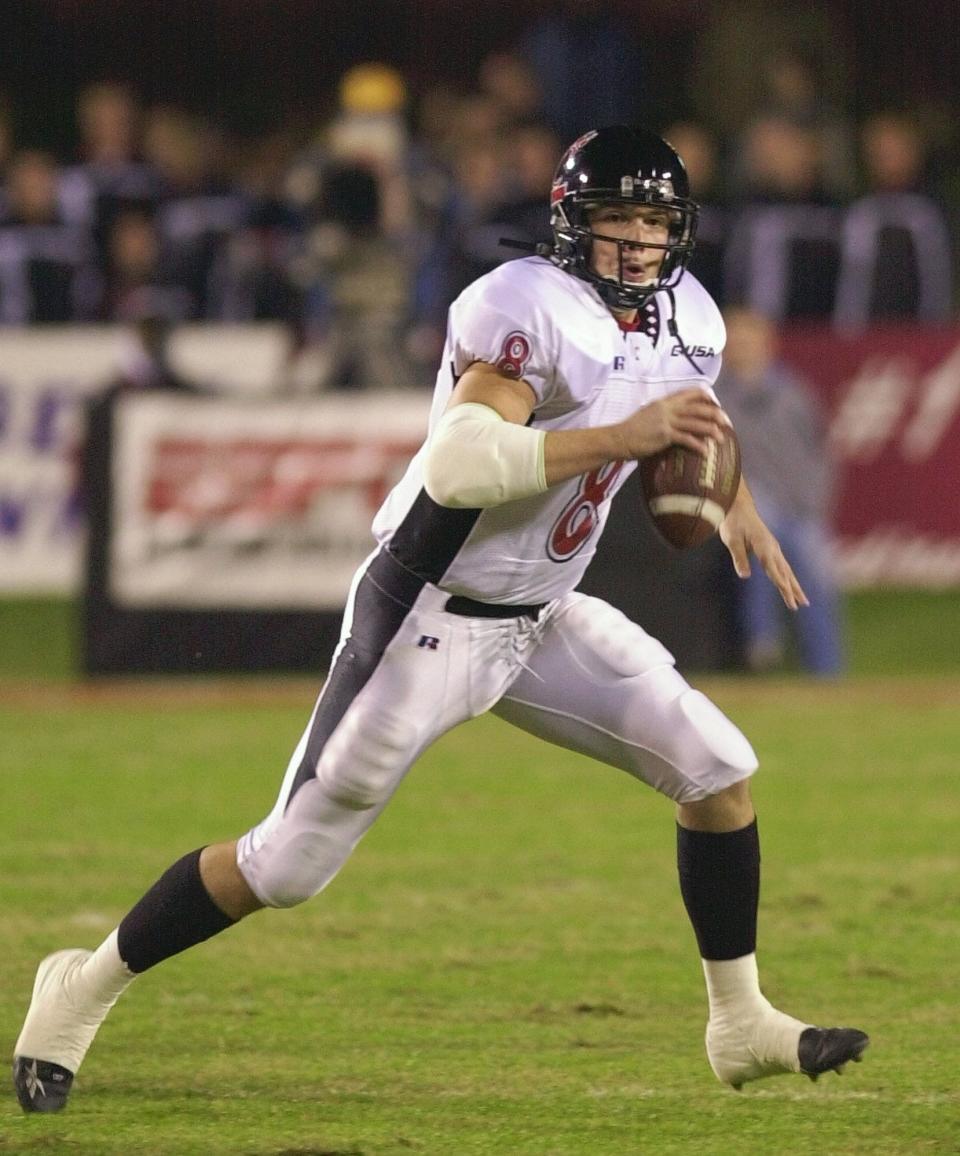 Cincinnati quarterback Gino Guidugli looks for a receiver as he rolls out during the first half against Louisville on Thursday, Nov. 7, 2002, in Louisville, Ky.