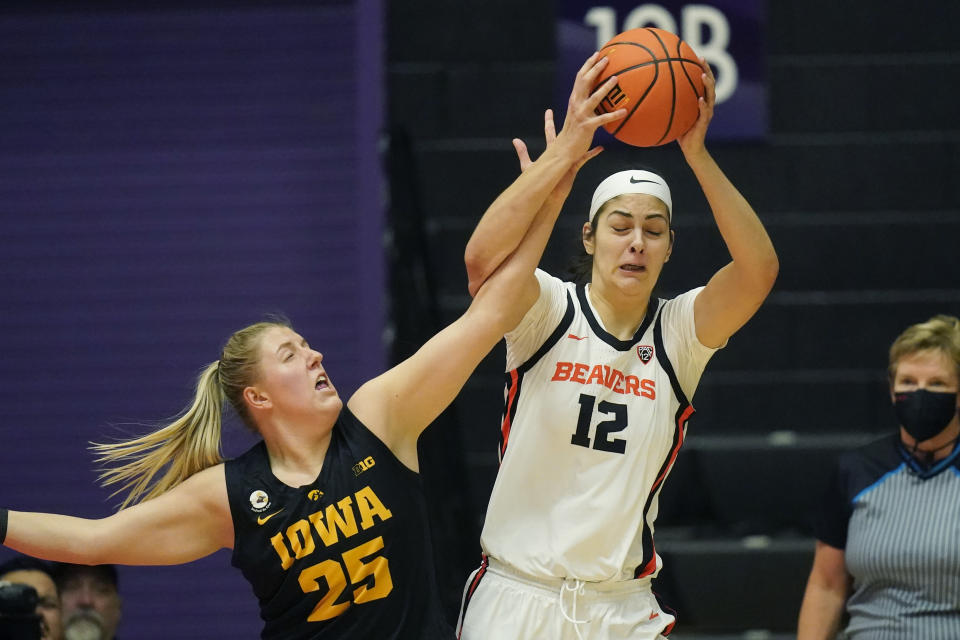Iowa forward Monika Czinano (25) defends against Oregon State forward Jelena Mitrovic (12) during the first half of an NCAA college basketball game in the Phil Knight Legacy tournament Friday, Nov. 25, 2022, in Portland, Ore. (AP Photo/Rick Bowmer)