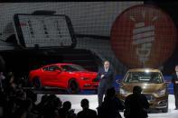 Marin Burela, president & CEO of Changan Ford Automobile Co., Ltd. unveils the Ford Escort sedan, right, during press day at the China Auto show in Beijing, China, Sunday, April 20, 2014. Ford Motor Co. on Sunday unveiled the new Escort sedan designed in China for global sale at a Beijing auto show that highlighted the growing influence of Chinese tastes on the industry. (AP Photo/Ng Han Guan)