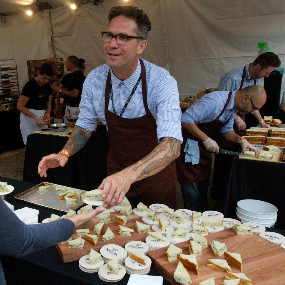 In this Sept. 20, 2012 photo, Jason French from the Ned Ludd restaurant serves shrimp and watercress tea sandwiches during the Feast Portland food festival in Portland, Ore. Far from the expectant gaze of major restaurant critics and the accompanying pressure to produce the Next Big Thing, the little-big city of Portland offers chefs a unique opportunity - the chance to experiment. (AP Photo/The Oregonian, Doug Beghtel)