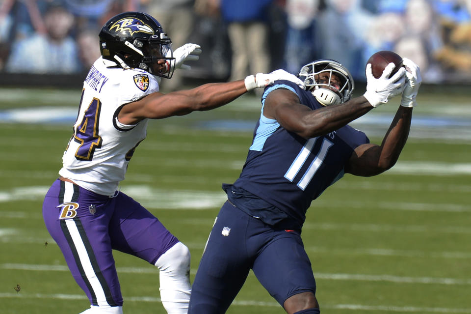 Tennessee Titans wide receiver A.J. Brown (11) makes a catch as he is defended by Baltimore Ravens cornerback Marlon Humphrey (44) in the first half of an NFL wild-card playoff football game Sunday, Jan. 10, 2021, in Nashville, Tenn. (AP Photo/Mark Zaleski)