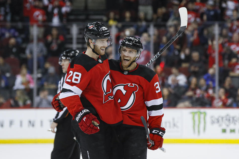 =New Jersey Devils defenseman Dakota Mermis, right, celebrates with defenseman Damon Severson (28) after scoring against St. Louis Blues goaltender Jordan Binnington during the second period of an NHL hockey game, Friday, March 6, 2020, in Newark. (AP Photo/John Minchillo)