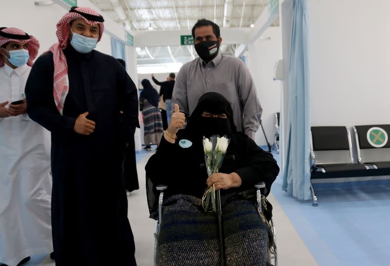 A Saudi woman gestures after she received the first dose of a coronavirus disease (COVID-19) vaccine, in Riyadh