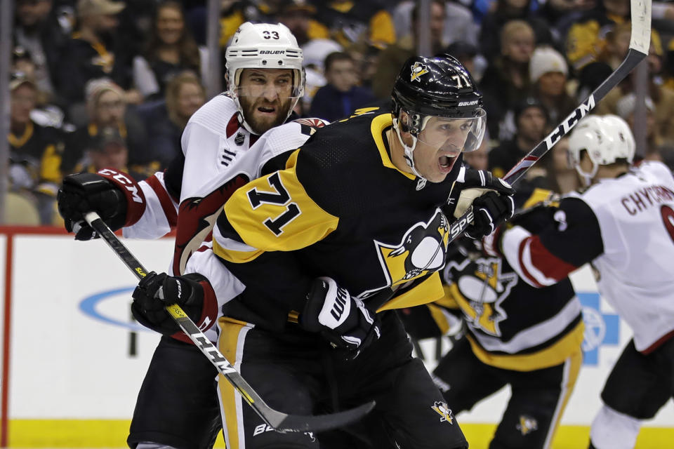 Pittsburgh Penguins' Evgeni Malkin (71) battles Arizona Coyotes' Alex Goligoski (33) for position in front of goalie Antti Raanta during the second period of an NHL hockey game in Pittsburgh, Friday, Dec. 6, 2019. (AP Photo/Gene J. Puskar)