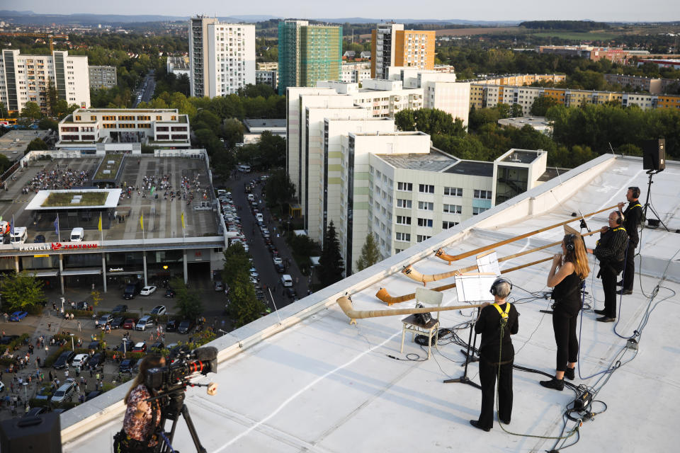 Musicians with alp horns perform on the roof of an apartment block for a concert featuring distant harmonies, at a time when cultural events have been disrupted by the coronavirus pandemic, in the Prohlis neighborhood in Dresden, Germany, Saturday, Sept. 12, 2020. About 33 musicians of the Dresden Sinfoniker perform a concert named the 'Himmel ueber Prohils', The Sky above Prohlis, on the roof-tops of communist-era apartment blocs in the Dresden neighborhood Prohlis. (AP Photo/Markus Schreiber)