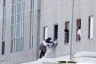 <p>A woman is evacuated during an attack on the Iranian parliament in central Tehran, Iran, June 7, 2017. (Photo: Tasnim News Agency/Handout via Reuters) </p>