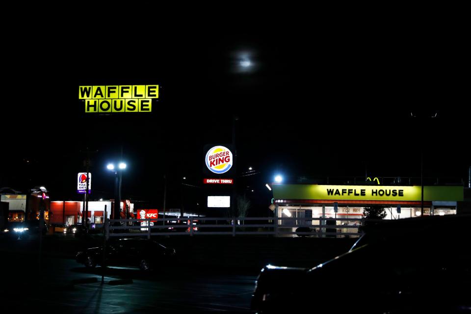 In this file photo, Waffle House, Burger King, and Taco Bell are among the restaurants with lit signs seen along a road at night in Burlington, N.C., Monday, March 9, 2020. Multiple people were shot at a Waffle House in Indianapolis on Monday, Feb. 19, 2024, police told media.