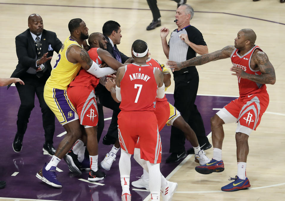 Houston Rockets' Chris Paul, second from left, is held back by Los Angeles Lakers' LeBron James, left, as Paul fights with Lakers' Rajon Rondo, center obscured, during the second half of an NBA basketball game Saturday, Oct. 20, 2018, in Los Angeles. The Rockets won, 124-115. (AP Photo/Marcio Jose Sanchez)