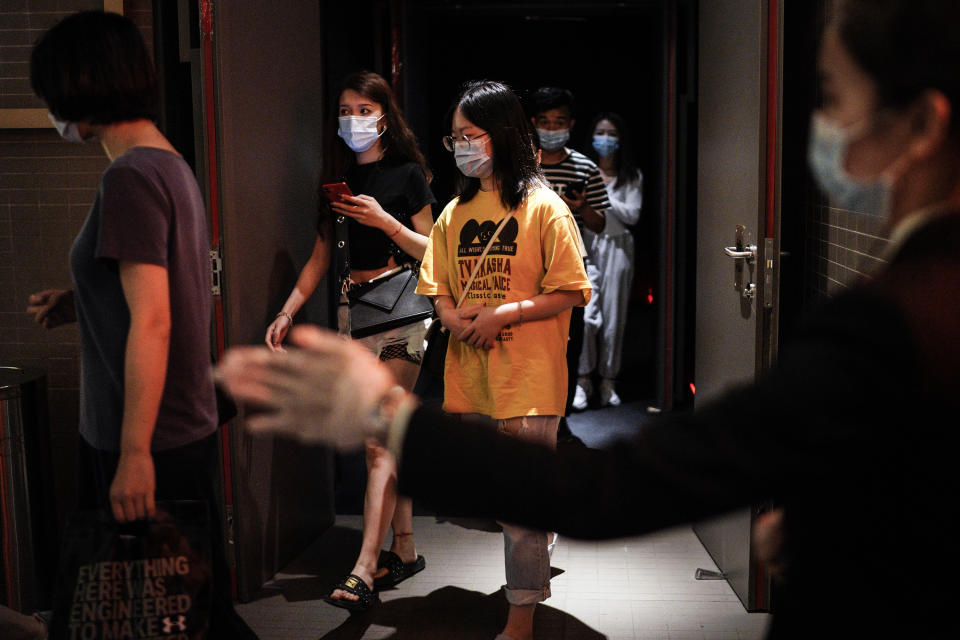 WUHAN, CHINA - JULY 20: (CHINA OUT)The employee wear the protective a mask while guides the audience through a passage to the exit in a cinema at Wuhan on July 20, 2020 in Wuhan ,Hubei Province,China.Taking various measures against COVID-19, cinemas in the city reopened in an orderly manner on Monday. The China Film Administration, in a circular last week, allowed cinemas in low-risk areas to resume operation with effective epidemic prevention measures in place. (Photo by Getty Images)