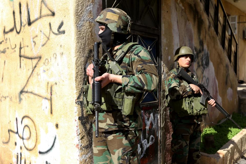 Lebanese army soldiers take their positions after clashes erupted between supporters and opponents of Syrian President Bashar Assad, near the Sunni neighborhood of Tariq Jadideh, in Beirut, Lebanon, Sunday, March 23, 2014. Syria-related clashes between supporters and opponents of Syrian President Bashar Assad have prompted Lebanese troops to deploy to a Beirut neighborhood to calm tensions. The Army deployment came after rival Sunni gunmen exchanged gunfire and rocket-propelled-grenades for several hours in the area, in the worst fighting in the Lebanese capital in nearly two years. (AP Photo/Hussein Malla)