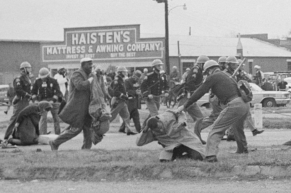 State troopers swing billy clubs to break up a civil rights voting march in Selma, Ala., March 7, 1965. About 600 people, including John Lewis, who would go on to serve 17 terms as a U.S. congressman, were attacked by state troopers as they tried to cross the Edmund Pettus Bridge leading out of Selma. TV cameras broadcast the assault in what became known as "Bloody Sunday" with demonstrations across the country over the next two days supporting the marchers. (AP Photo/File)