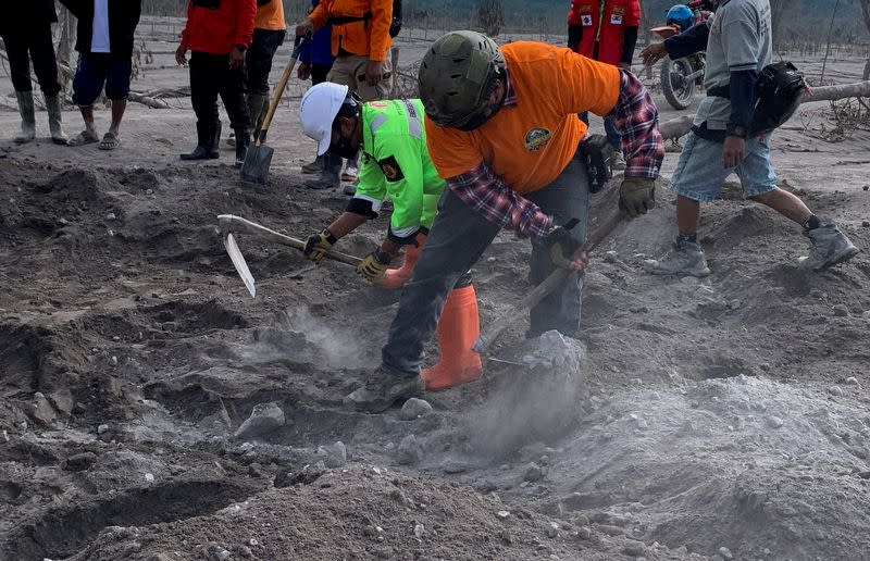 Dodik Suryadiawan, a 36-year-old volunteer rescuer digs the soil during a rescue operation following the eruption of Mount Semeru volcano in Curah Kobokan village, Pronojiwo district, in Lumajang