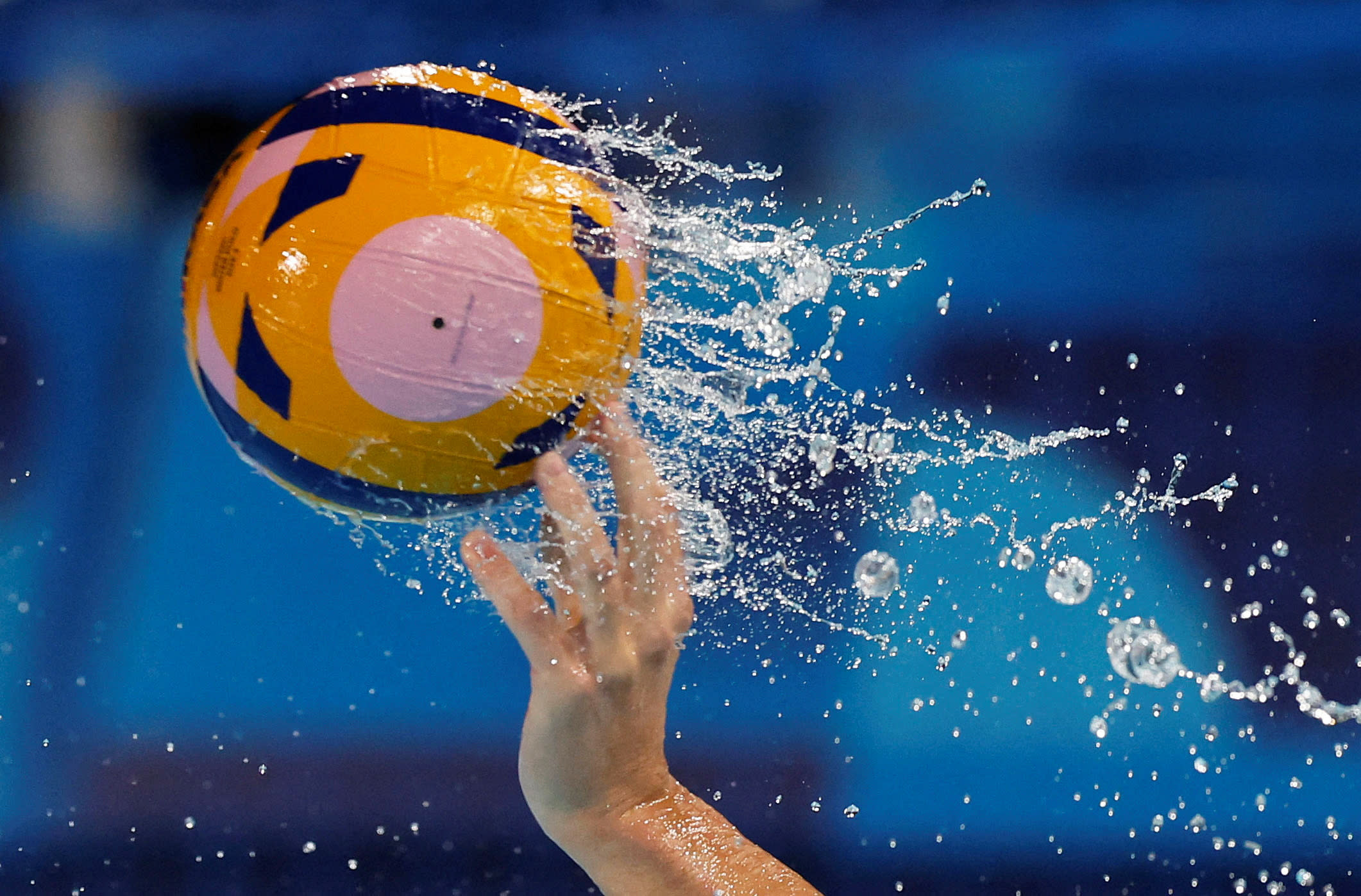 The hand of Konstantin Kharkov of Croatia passes the water polo ball against Montenegro in St. Denis.