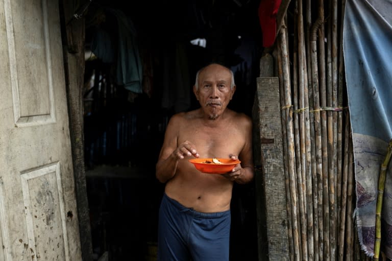 El indígena guna Alberto López desayuna en la puerta de su casa, en la isla de Cartí Sugdupu, en Guna Yala, Panamá, el 3 de junio de 2024 (MARTIN BERNETTI)