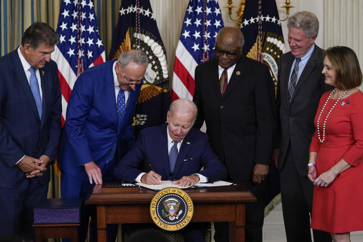 President Biden signs the Democrats' landmark climate change and health care bill in the State Dining Room of the White House in Washington, Tuesday, Aug. 16, 2022, as from left, Sen. Joe Manchin, D-W.Va., Senate Majority Leader Chuck Schumer of N.Y., House Majority Whip Rep. James Clyburn, D-S.C., Rep. Frank Pallone, D-N.J., and Rep. Kathy Castor, D-Fla., watch. (Susan Walsh/AP)