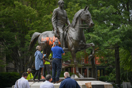 Municipal workers attempt to remove paint from a monument dedicated to Confederate soldier John B. Castleman that was vandalized late Saturday night in Louisville, Kentucky, U.S., August 14, 2017. REUTERS/Bryan Woolston