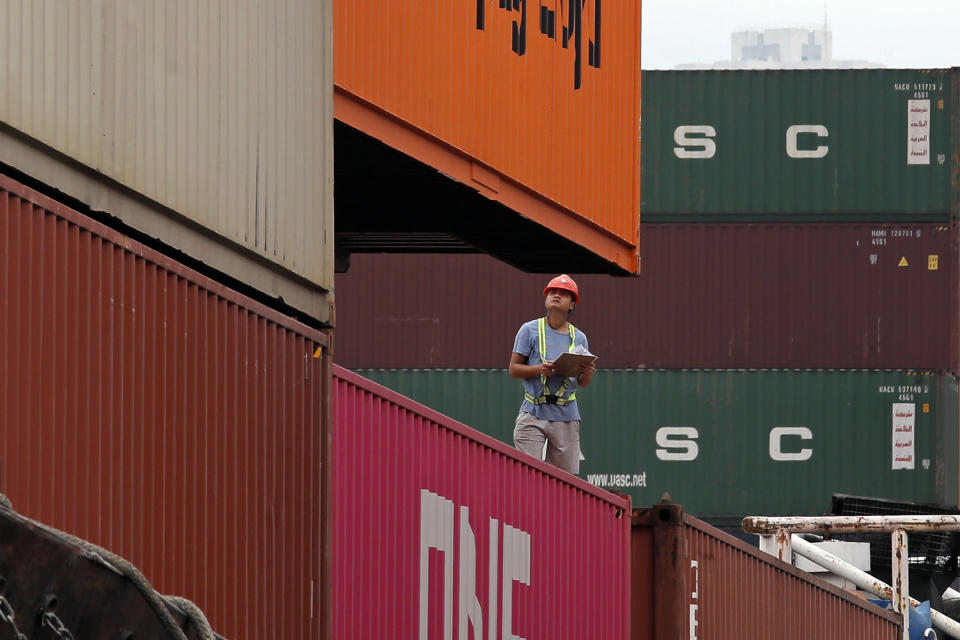 A staff member checks cargos at a port of Kwai Tsing Container Terminals in Hong Kong, Friday, May 24, 2019. Kwai Tsing Container Terminals is one of the busiest ports in the world. (AP Photo/Kin Cheung)