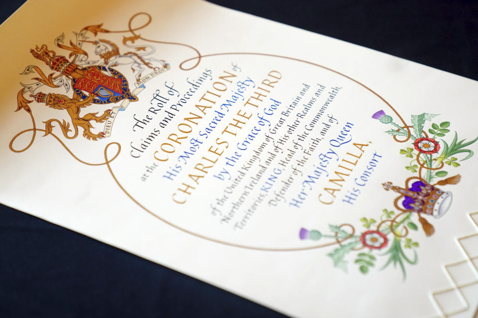 King Charles III and Queen Camilla are presented with the Coronation Roll, an official record of their Coronation, by the Clerk of the Crown in Chancery, at Buckingham Palace, central London, Wednesday May 1, 2024. King Charles III gaped at the 70-foot-long (21.4-meter) hand-lettered scroll as it was presented to him earlier this week at Buckingham Palace, thanking the artisans who produced the document that serves as the official record of his coronation almost a year ago. (Victoria Jones/PA via AP)