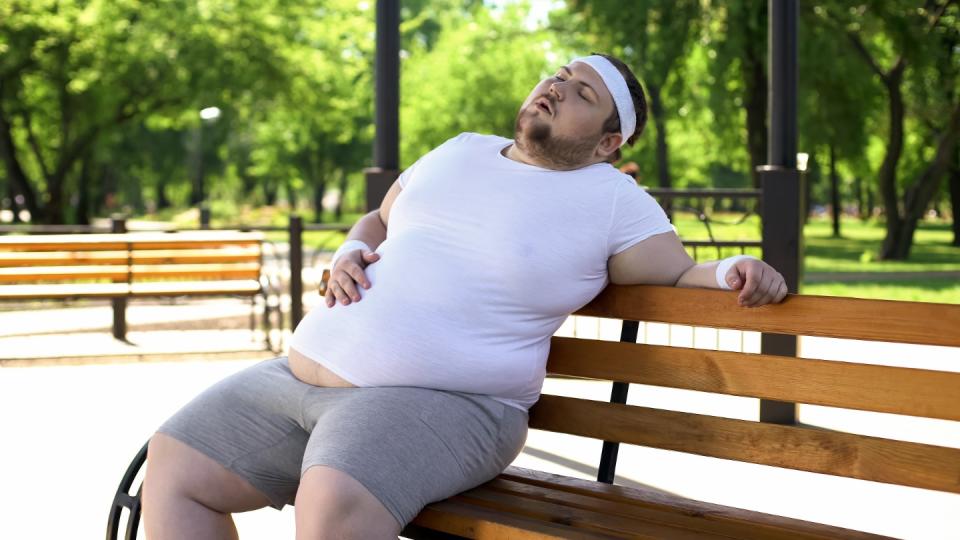 A big young man suffering from fatty liver disease feels the side of his stomach. (Photo; Getty Images)
