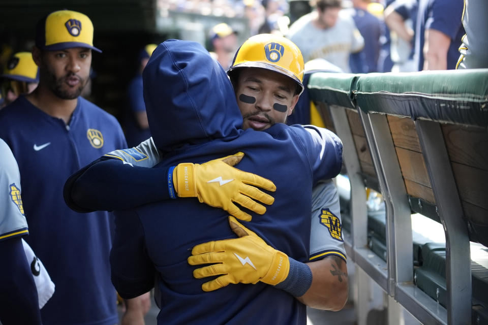 Milwaukee Brewers' Blake Perkins, right, is hugged in the dugout by Andruw Monasterio after Perkins' two-run home run in the seventh inning of a baseball game Chicago Cubs Saturday, May 4, 2024, in Chicago. (AP Photo/Charles Rex Arbogast)