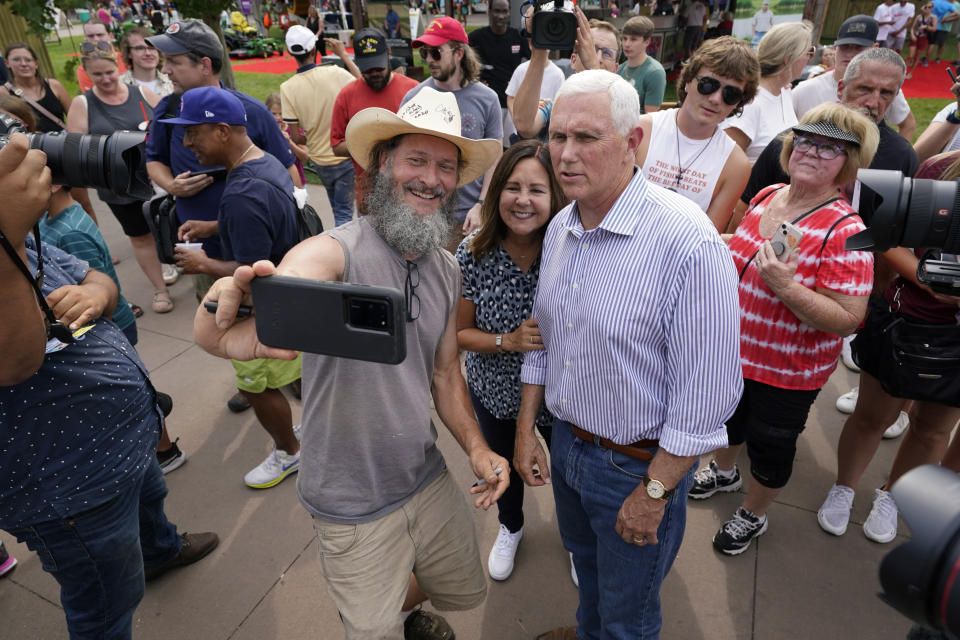 Republican presidential candidate former Vice President Mike Pence and his wife Karen, center, pose for a photo with a fairgoer during a visit to the Iowa State Fair, Thursday, Aug. 10, 2023, in Des Moines, Iowa. (AP Photo/Charlie Neibergall)