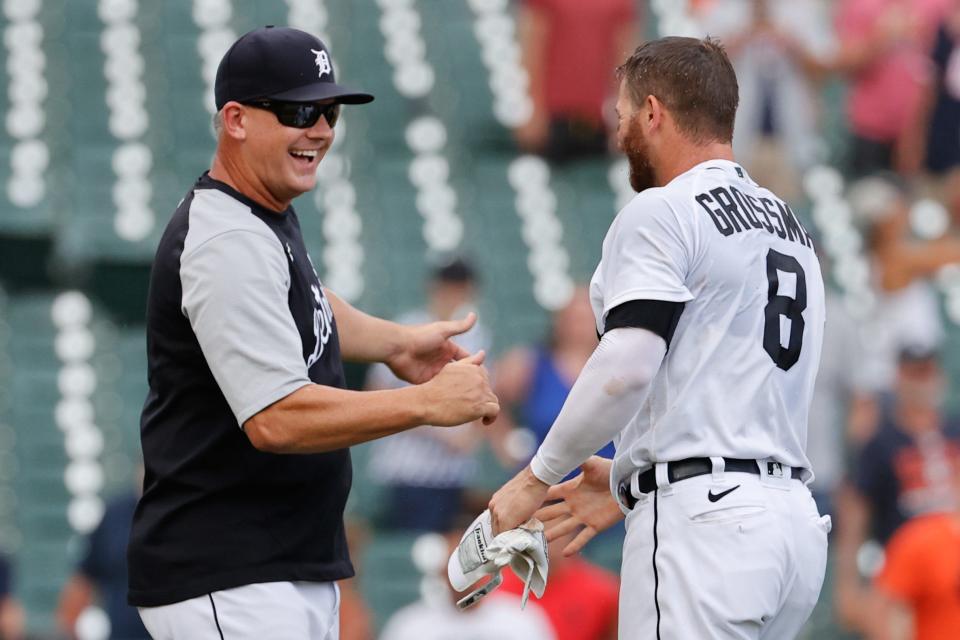 Detroit Tigers left fielder Robbie Grossman (8) is congratulated by manager A.J. Hinch (14)  after he bunts in the winning run in the 10th inning June 27, 2021 against the Houston Astros at Comerica Park.