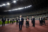 IOC President Thomas Bach, center, visits the National Stadium, the main venue for the 2020 Olympic and Paralympic Games postponed until July 2021 due to the coronavirus pandemic, in Tokyo Tuesday, Nov. 17, 2020. Bach said during this week's trip to Tokyo that he is “encouraging” all Olympic “participants” and fans to be vaccinated - if one becomes available - if they are going to attend next year's Tokyo Olympics. (Behrouz Mehri/Pool Photo via AP)