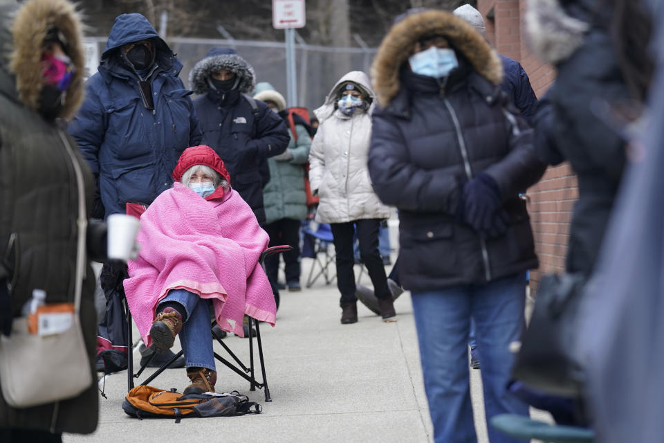 Judy McKim, center left, waits in line with others for the COVID-19 vaccine in Paterson, N.J., Thursday, Jan. 21, 2021. The first people arrived around 2:30 a.m. for the chance to be vaccinated at one of the few sites that does not require an appointment. (AP Photo/Seth Wenig)