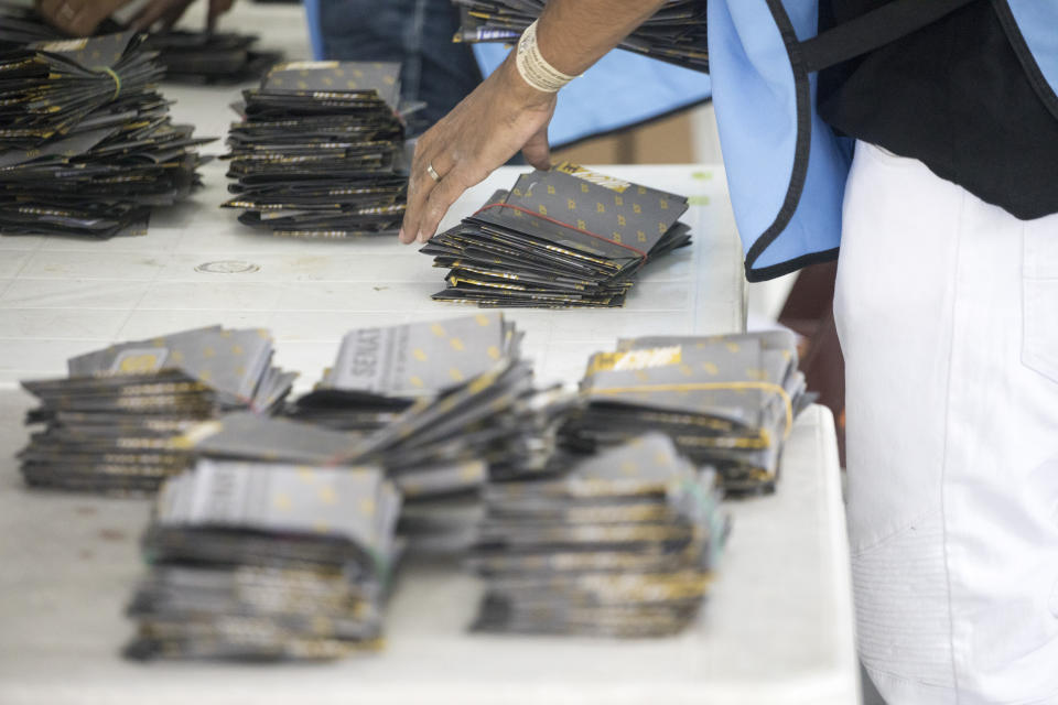 Electoral officials wearing protective masks as a precaution against the spread of the new coronavirus, count ballots after polls closed during the presidential elections, in Santo Domingo, Dominican Republic, Sunday, July 5, 2020. (AP Photo/Tatiana Fernandez)