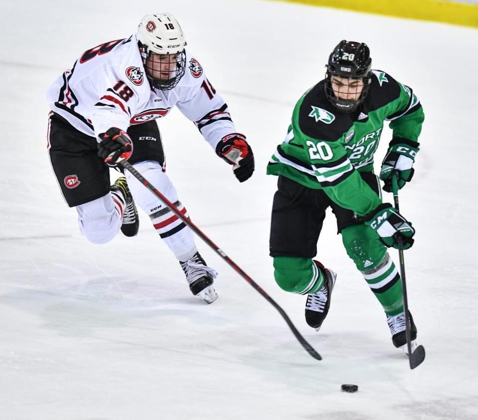 St. Cloud State's Brendan Bushy tries to get the puck from Nick Portz of North Dakota during the first period of the game Friday, Dec. 3, 2021, at the Herb Brooks National Hockey Center in St. Cloud.
