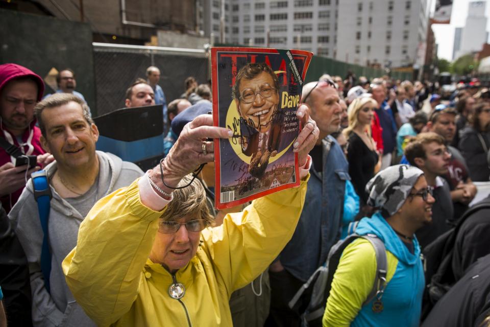 A fan holds up a magazine with David Letterman's face on it outside of Ed Sullivan Theater in Manhattan