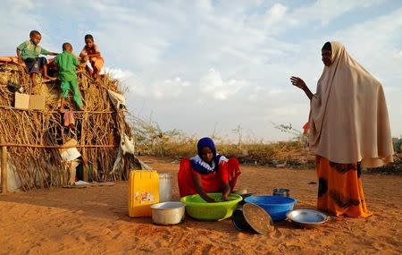 Zeinab, 14, (C) washes dishes as her mother Abdir Hussein gestures and her nephews play at a camp for internally displaced people from drought hit areas in Dollow, Somalia April 3, 2017. REUTERS/Zohra Bensemra