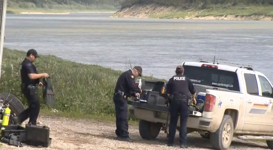 Photo shows police searching an area close to the Nelson River where a boat and items of interest in relation to the search for Bryer Schmegelsky and Kam McLeod were found last Friday.