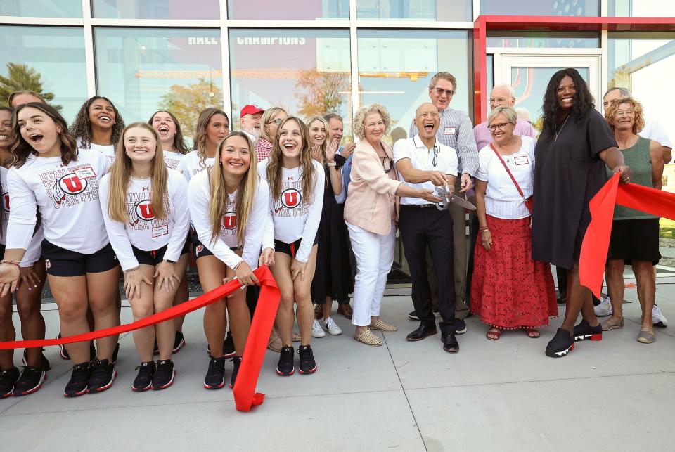 Utah gymnastics head coach Tom Farden holds the scissors during a ribbon-cutting event for the Dumke Gymnastics Center’s expansion.