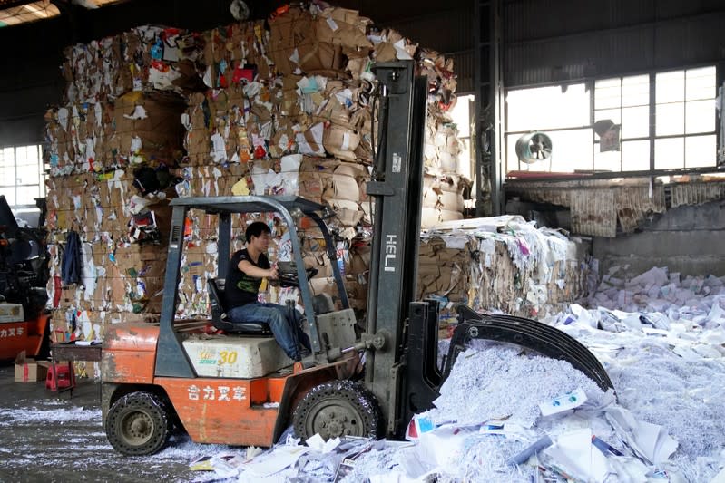 A laborer works at a paper products recycling station in Shanghai