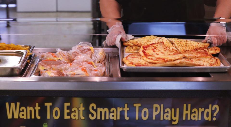 A cafeteria work puts out a tray of pizza as they prepare for lunch at Nordonia High School on Thursday.