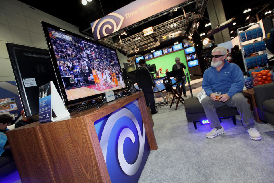 A consumer watches TV in 3D at the Time Warner Cable Sports Step Thru the Screen Interactive Booth at NBA Jam Session, in Los Angeles, on Thursday, Feb. 17, 2011. (Casey Rodgers / AP Images for Time Warner Cable Sports)