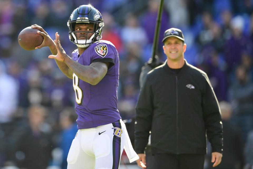 Baltimore Ravens quarterback Lamar Jackson (8) passes as head coach John Harbaugh looks prior to the game against the Los Angeles Chargers in a AFC Wild Card playoff football game at M&T Bank Stadium.