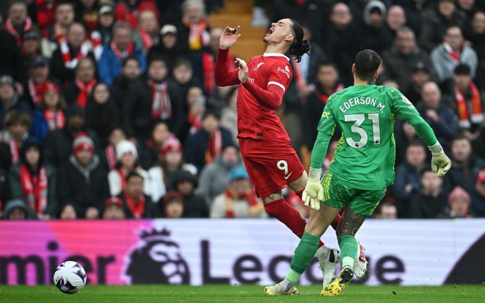 Manchester City's Brazilian goalkeeper #31 Ederson fouls Liverpool's Uruguayan striker #09 Darwin Nunez