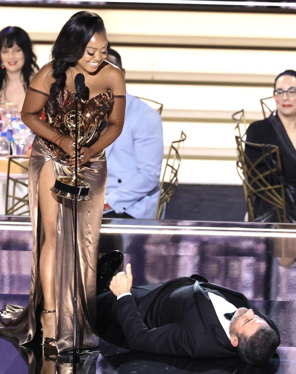 Quinta Brunson accepts the Outstanding Writing for a Comedy Series award for ‘Abbott Elementary’ from (lying on the stage) onstage during the 74th Primetime Emmys
